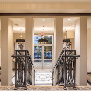 A luxurious interior featuring a grand staircase leading to a well-lit entrance.