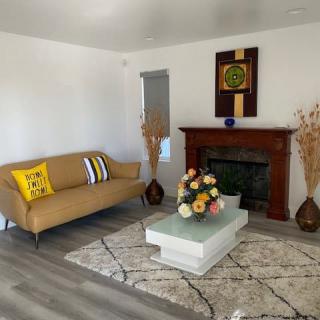 A modern living room featuring a sofa, coffee table, and fireplace adorned with decor.