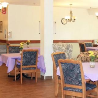 A cozy dining room with decorated tables and floral arrangements.
