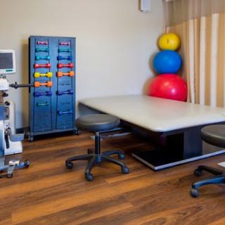 A well-equipped physical therapy room with exercise balls and medical equipment.