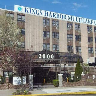 The exterior of Kings Harbor Multicare Center, showcasing its entrance and building facade.