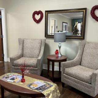 Cozy living room with armchairs, a mirror, and heart-shaped wall decor.