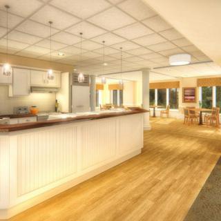 A spacious and modern kitchen with a large countertop, wood flooring, and stylish lighting.