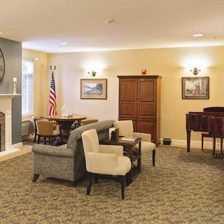 A cozy living room with comfortable seating, a fireplace, and a piano.