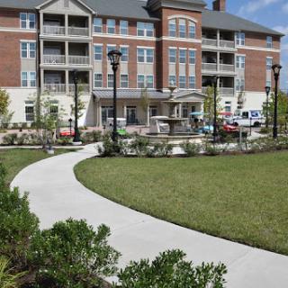 A well-designed residential building with landscaped surroundings and a winding pathway.