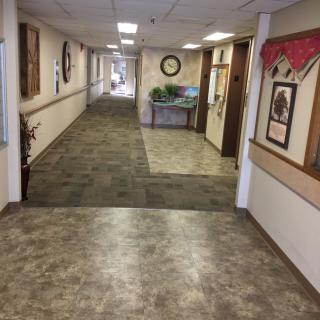 A long hallway with carpeted flooring and wall decorations.