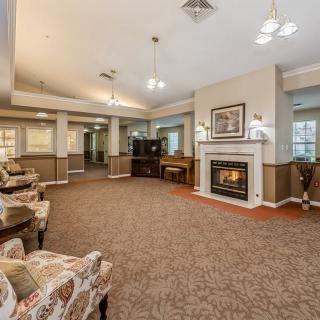A cozy living room with a fireplace, comfortable seating, and warm lighting.