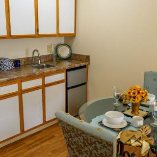 A cozy kitchen and dining area with a table set for two.