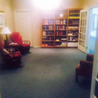 A cozy living room featuring bookshelves and comfortable seating.