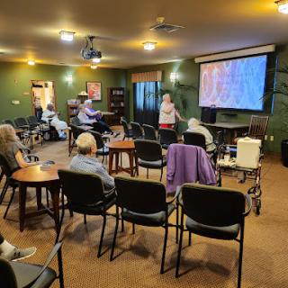 A community gathering where an individual presents to an audience of elderly attendees.