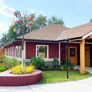 A charming red building with a well-maintained garden and wooden accents.