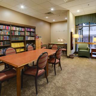 A cozy library reading area with a bookshelf and seating.
