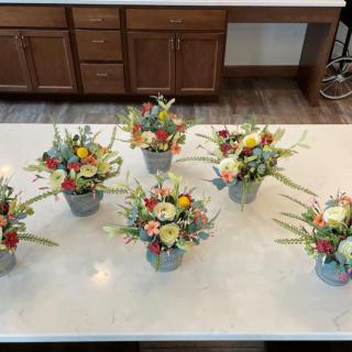 Six vibrant floral arrangements displayed on a kitchen countertop.