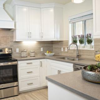 A modern kitchen featuring sleek white cabinets and stainless steel appliances, designed for both functionality and style.