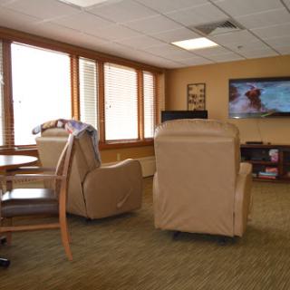 A cozy lounge area featuring comfortable chairs and a television, perfect for relaxation.