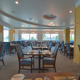 An empty restaurant dining area with neatly arranged tables and chairs.