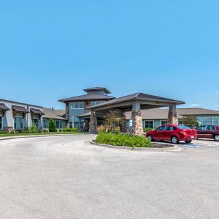 A modern commercial building with a parking lot and cars in front.