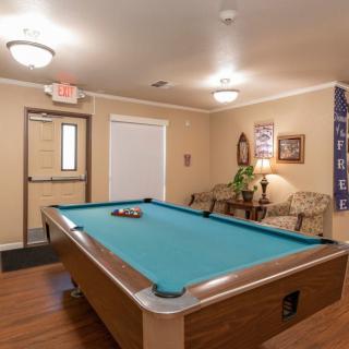 A cozy game room featuring a pool table and comfortable seating.