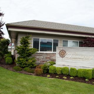 A well-maintained building with landscaped greenery and a visible sign in front.