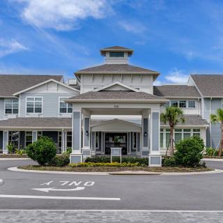 A modern residential building with a grand entrance under a blue sky.