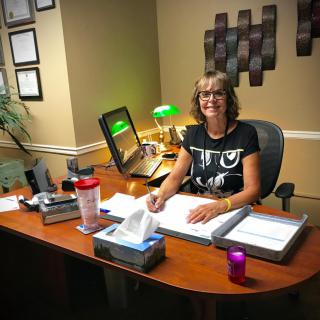 A woman sitting at her desk in a well-organized office setting.