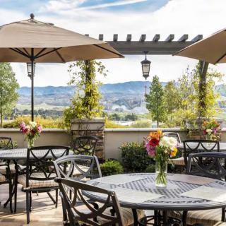 A scenic patio with outdoor seating, adorned with flowers and offering a beautiful landscape view.