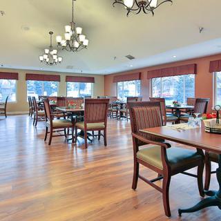 A spacious dining area with wooden furniture and large windows.