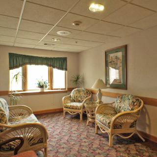 A cozy waiting room with wicker chairs and a window view.