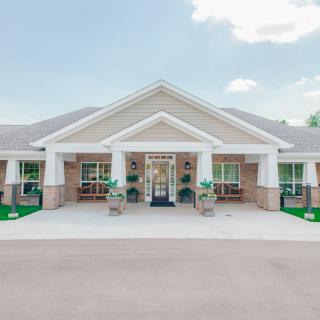 A symmetrical brick building with a prominent entrance and decorative columns.