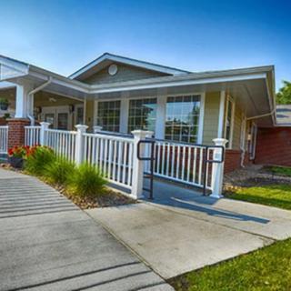 A charming bungalow with a white fence and well-maintained front yard.