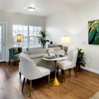 A modern living and dining area featuring stylish furniture, hardwood floors, and contemporary artwork.