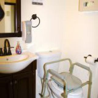 An accessible bathroom with handrails and a sink.