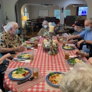 A group of people enjoying a meal together at a dining table indoors.