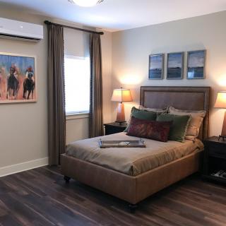 A cozy bedroom with a plush bed, nightstands, and decorative artwork.