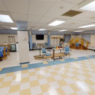 A spacious rehabilitation center equipped with various physical therapy apparatus and exercise equipment.