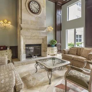 A luxurious living room featuring elegant furniture and a grand fireplace.