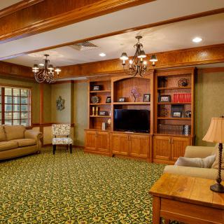 A cozy living room with elegant furniture and wooden cabinetry.
