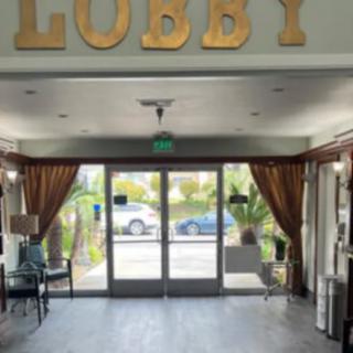 A hotel lobby area with seating and glass doors leading outside.