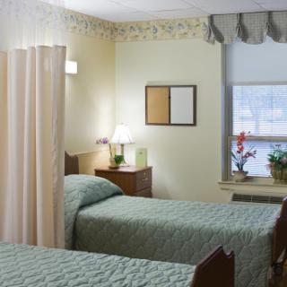 A well-lit hospital room with two beds, featuring a cozy atmosphere and decorative elements.