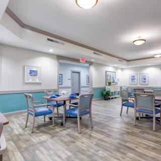 A well-lit dining area with neatly arranged tables and chairs, featuring modern dcor and flooring.