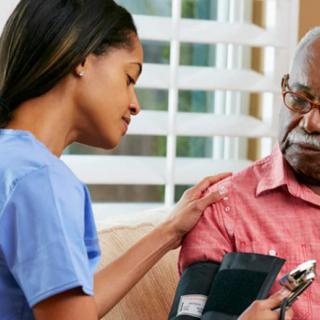 A nurse checking the blood pressure of an elderly patient at home.