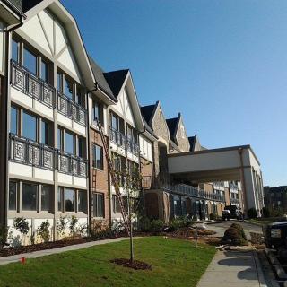 A modern residential building with well-maintained landscaping on a sunny day.