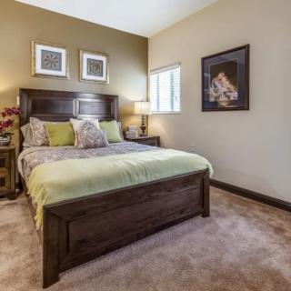 Cozy bedroom with a wooden bed frame, soft bedding, and decorative artwork on the wall.