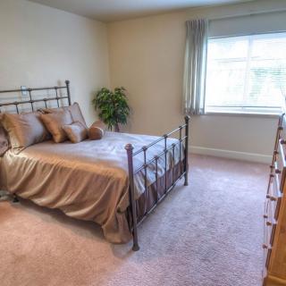 A cozy bedroom with a metal-framed bed and natural light coming through the window.
