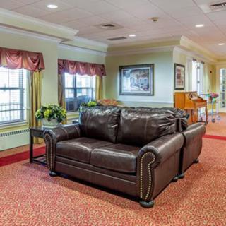 A cozy living room with a dark leather sofa and elegant decor.