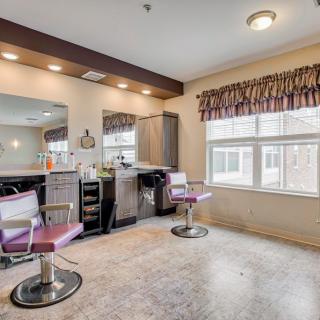 A spacious and well-lit hair salon interior with chairs and mirrors.