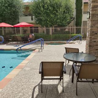 A tranquil poolside view with seating, perfect for relaxation on a sunny day.