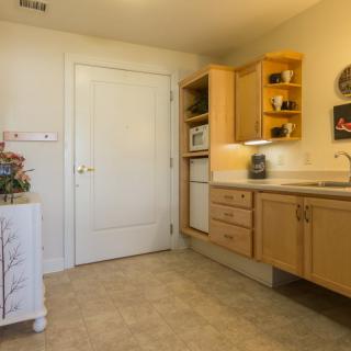 A cozy kitchen interior featuring wooden cabinets and a countertop with a microwave.