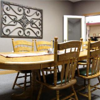 A cozy dining room with a wooden table and chairs, adorned with decorative wall art.