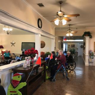 A cozy lobby area in a care facility, adorned with holiday decorations and residents gathered together.
